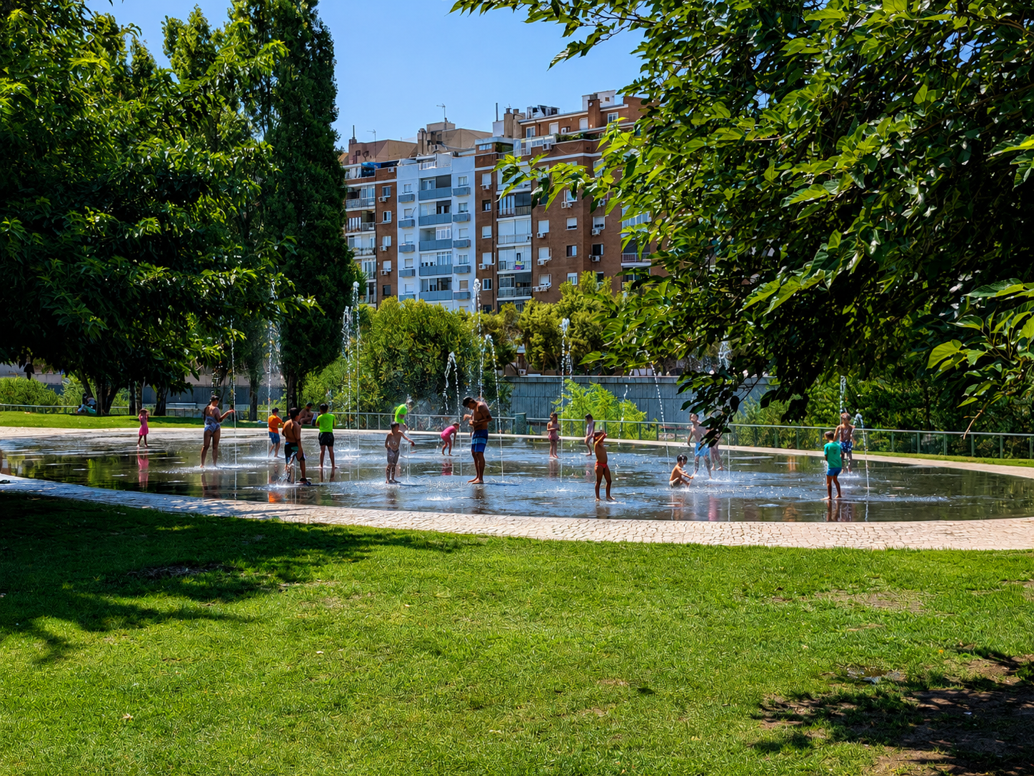 Bambini giocano tra fontane in un parco cittadino
